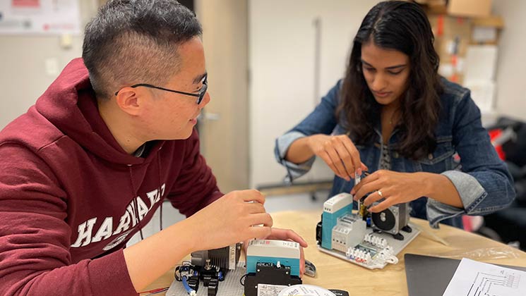 Two student researchers assembling equipment