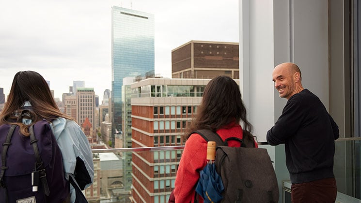 A group of students surveys a city skyline