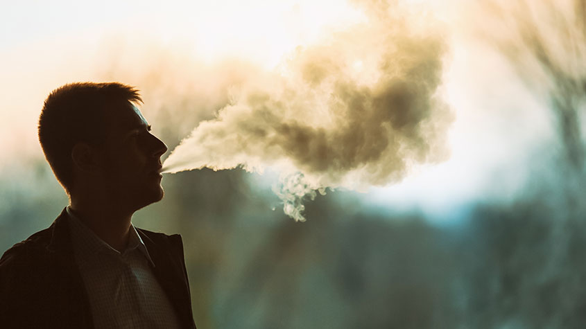 A man blowing e-cigarette vapor